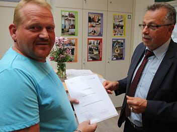 Der stellvertretende Landrat Emil Müller (rechts) übergab die Urkunden. Ralf Bartenstein ist jetzt einer von drei Tagesvätern. Fotos: Ronald Heck