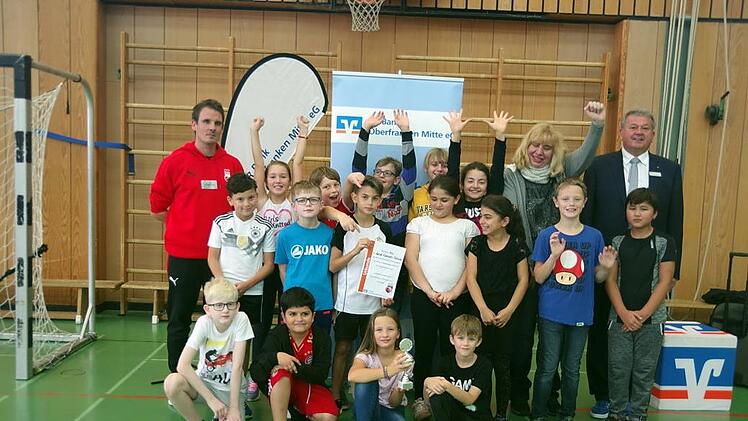 Die Klasse 4 a der Lucas-Cranach-Grundschule Kronach gewann den Wurfwettbewerb-Pokal, der von der VR Bank Oberfranken Mitte vergeben wurde. Mit den Siegern und ihrer Lehrerin freuten sich auch (links) Brose Bamberg-Jugendkoordinator Sebastian Böhnlein sowie VR-Bereichsdirektor Hans Jürgen Möhrle (rechts)Heike Schülein