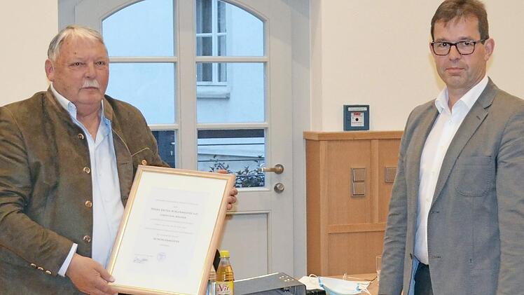 Christian Mrosek erhält die Urkunde mit der Verleihung der Ehrenbezeichnung "Altbürgermeister".  Foto: Thomas Micheel