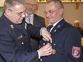 Wolfgang Wohlrath (r.) wurde das Ehrenzeichen in Gold des Freistaates Bayern verliehen. Beim Anstecken KBI Matthias Schuhbäck, mit im Bild Bürgermeister Egon Herrmann