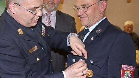Wolfgang Wohlrath (r.) wurde das Ehrenzeichen in Gold des Freistaates Bayern verliehen. Beim Anstecken KBI Matthias Schuhbäck, mit im Bild Bürgermeister Egon Herrmann