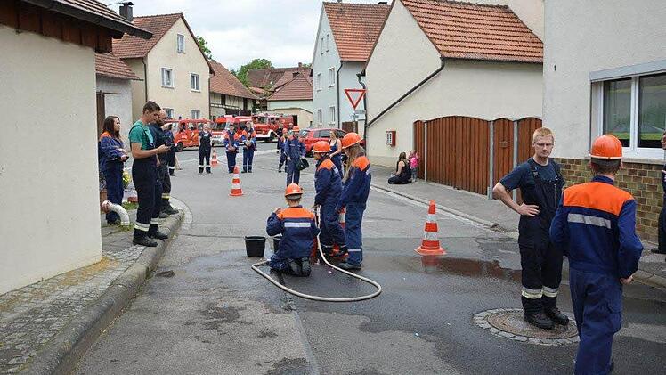 Station in Weisbrunn beim Wasserbombenfüllen mit der Kübelspritze.