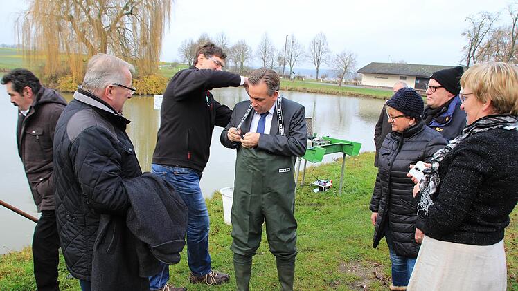 Landrat Alexander Tritthart (Mitte) bekam  vom BBV-Kreisobmann Robert Ort (hinten links) eine Wathose geschenkt. Foto: Andreas Dorsch