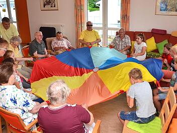 Jung und Alt hatten besonders viel Freude beim Spielen mit dem großen Schwungtuch. Ein Schuljahr lang besuchten Kinder der Henneberg-Grundschule Senioren in der "Kissinger Sonne" in Garitz und spielten, bastelten und sangen mit ihnen.  Foto: Peter Rauch