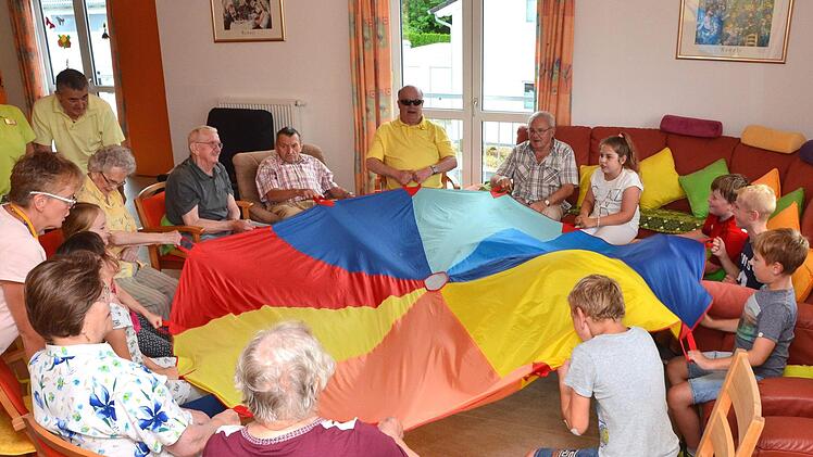 Jung und Alt hatten besonders viel Freude beim Spielen mit dem großen Schwungtuch. Ein Schuljahr lang besuchten Kinder der Henneberg-Grundschule Senioren in der "Kissinger Sonne" in Garitz und spielten, bastelten und sangen mit ihnen.  Foto: Peter Rauch