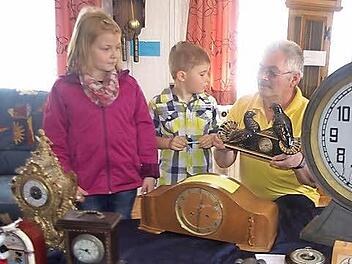 ) Edgar Wich zeigt seinen Enkelkindern Kilian Fischer und Celine Geiger die Uhr, die er von seinem Schwiegervater geerbt hat. Foto: Heike Schülein