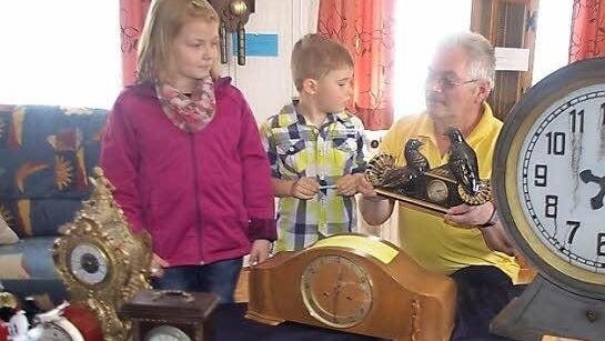 ) Edgar Wich zeigt seinen Enkelkindern Kilian Fischer und Celine Geiger die Uhr, die er von seinem Schwiegervater geerbt hat. Foto: Heike Schülein