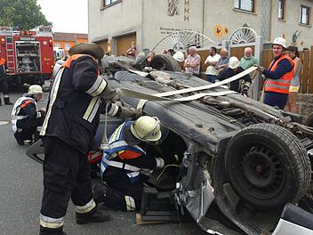 Bei einer Schauübung in Eltingshausen haben Feuerwehrleute aus Oerlenbach einen überschlagenen Pkw gesichert. Sie setzten Spreitzer und Schere ein, um eine eingeklemmte Person zu befreien. Fotos: Stefan Geiger