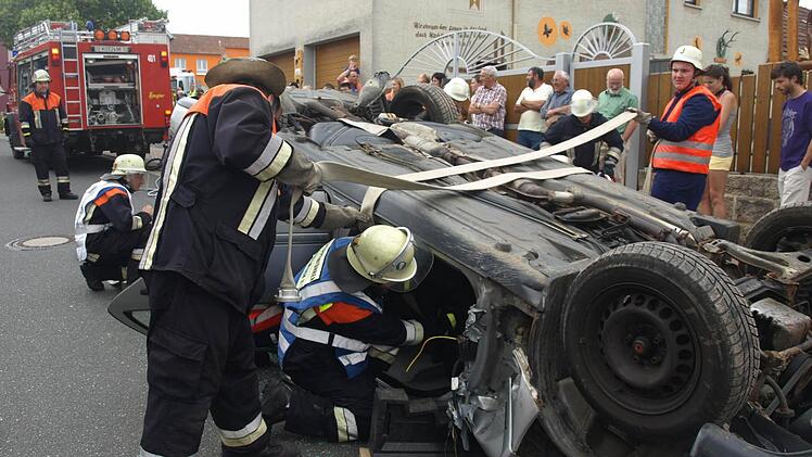 Bei einer Schauübung in Eltingshausen haben Feuerwehrleute aus Oerlenbach einen überschlagenen Pkw gesichert. Sie setzten Spreitzer und Schere ein, um eine eingeklemmte Person zu befreien. Fotos: Stefan Geiger
