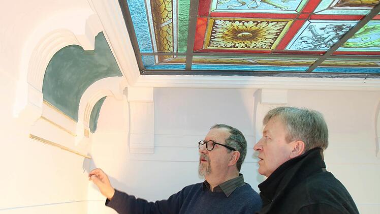 Restaurator Harald Straßburger und Architekt Ralf Alsheimer begutachten ein Farbmuster unter der Buntglasdecke des Treppenhauses. Foto: Ralf Ruppert