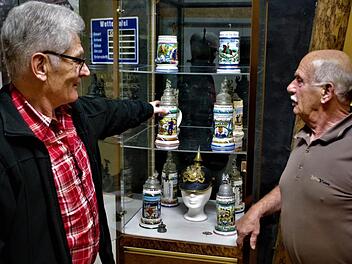 Kunstvoll gestaltete, über 100 Jahre alte Reservistenkrüge können im bergbaulichen Magazin zu Stockheim begutachtet werden. Im Bild Gerwin Eidloth (rechts) und Günther Scheler. Foto: Gerd Fleischmann