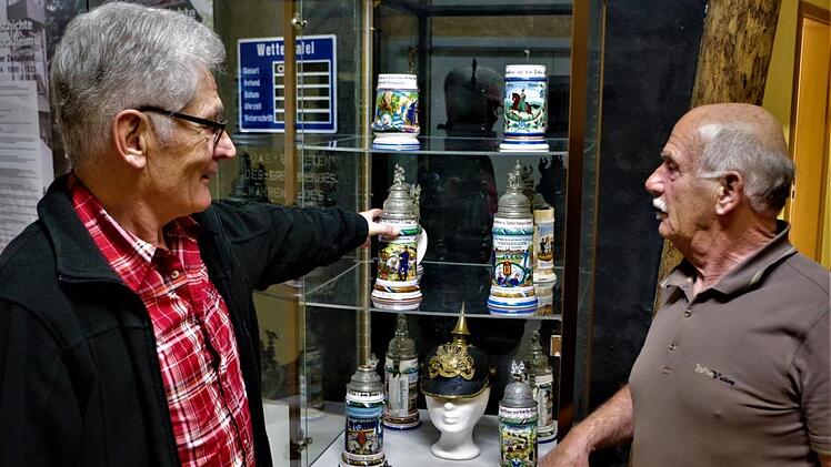 Kunstvoll gestaltete, über 100 Jahre alte Reservistenkrüge können im bergbaulichen Magazin zu Stockheim begutachtet werden. Im Bild Gerwin Eidloth (rechts) und Günther Scheler. Foto: Gerd Fleischmann
