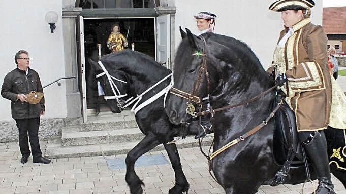 Die Reiter vom Friesenhof in Sassanfahrt vor dem Heiligen Stephanus in der Tür der Pfarrkirche.