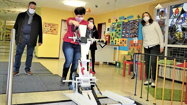 Christina Heisinger erklärt die Funktionsweise der neuen Treppenraupe, die seit sechs Wochen im Burghaiger Schulhaus im Einsatz ist. Mit im Bild (von links) OB Ingo Lehmann, Lisa Pietsch, Leiterin der Schulverwaltung der Stadt, und Schulleiterin Stephanie Rohde Foto: Werner Reißaus