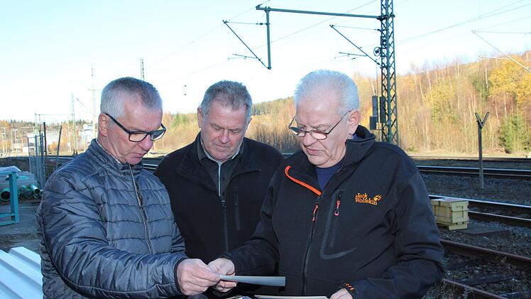 Die ehemaligen Culemeyer-Fahrer Joseph Reuth (rechts) und Heinrich Wicklein schauen sich zusammen mit Adam Fehn (Mitte), der sie als Rangiermeister mit der Fracht versorgte, alte Fotos an. Foto: Andreas Schmitt