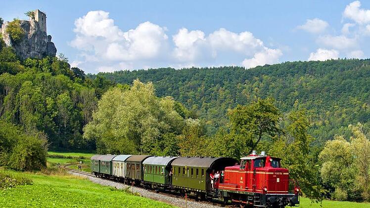 Die Museumsbahn fährt mit der Diesellok V60 unterhalb der Burgruine Neideck. Foto: Florian Fraaß