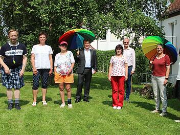 Der Beauftragte der Bundesregierung für Menschen mit Behinderung, Jürgen  Dusel (mit Schirm) besuchte ein Wohnheim der Lebenshilfe in Bad  Kissingen. (2. von rechts) die SPD-Bundestagsabgeordnete Sabine Dittmar,  (links daneben) der Geschäftsführende Vorstand der Lebenshilfe in Bad  Kissingen, Alex Iffert. (3. von links) die Vorsitzende des  Lebenshilfe-Aufsichtsrates, Monika Fella. Außerdem auf dem Bild  Mitarbeiterinnen der Lebenshilfe und Heimbewohner.