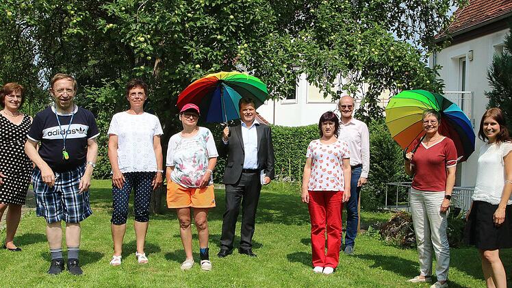 Der Beauftragte der Bundesregierung für Menschen mit Behinderung, Jürgen  Dusel (mit Schirm) besuchte ein Wohnheim der Lebenshilfe in Bad  Kissingen. (2. von rechts) die SPD-Bundestagsabgeordnete Sabine Dittmar,  (links daneben) der Geschäftsführende Vorstand der Lebenshilfe in Bad  Kissingen, Alex Iffert. (3. von links) die Vorsitzende des  Lebenshilfe-Aufsichtsrates, Monika Fella. Außerdem auf dem Bild  Mitarbeiterinnen der Lebenshilfe und Heimbewohner.