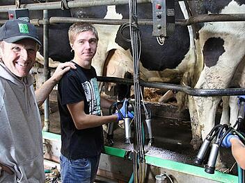 Herbert Kunick (links), Bio-Landwirt in Sonnefeld, mit den zwei russischen Praktikanten Fedor Raguzin (mitte) und Vladimir Nikulin beim Melken der Kühe  Foto: Christian Dreßel