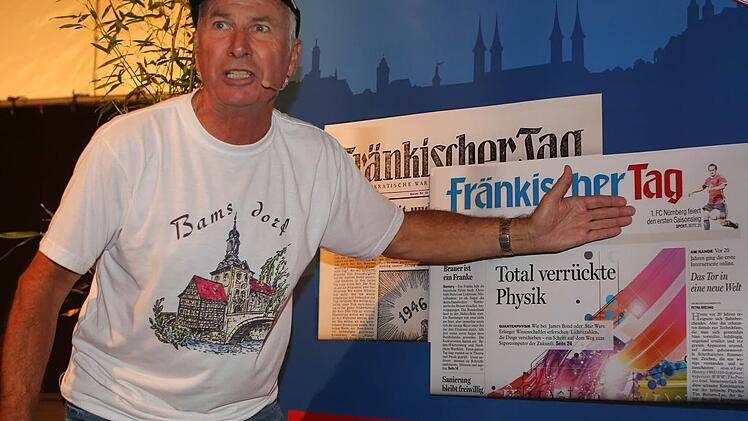 Wolfgang Reichmann kann es nicht glauben: Auf dem Plakat zu "70 Jahre Fränkischer Tag" ist vom ersten Saisonsieg des 1. FC Nürnberg die Rede. Foto: RiegerPress