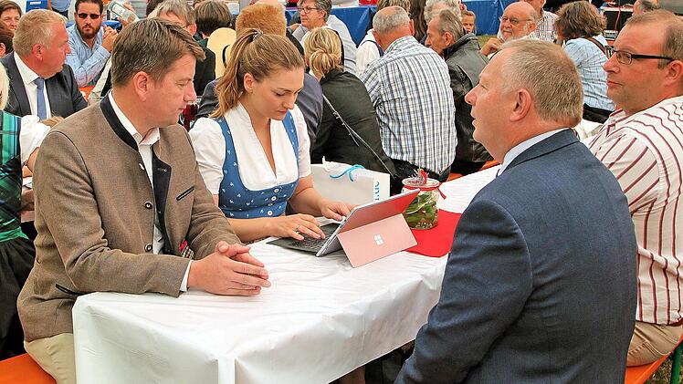 Digitalministerin Judith Gerlach fügte vor ihrer Rede in Thundorf noch  schnell ein paar Sätze ins digitale Manuskript ein. Schirmherr und  Landtagsabgeordneter Sandro Kirchner (links) assistierte. Rechts Landrat  Thomas Bold und der TSV-Vorsitzende Dieter Büchner. Foto: Dieter Britz