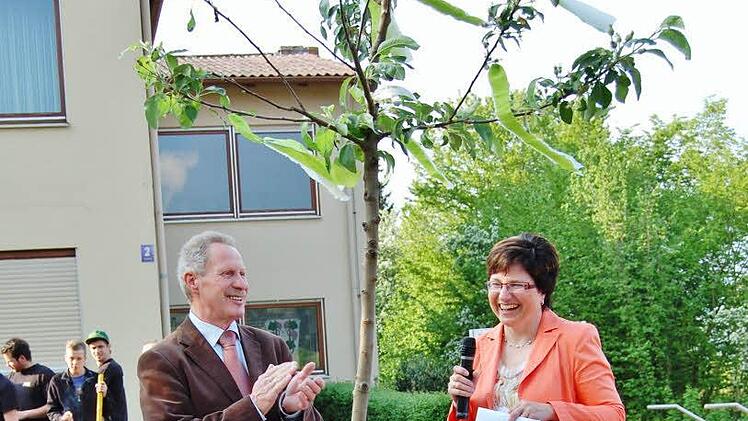 Bürgermeisterin Patricia Schießer schenkt Amtsvorgänger Reinhard Hallhuber ein Apfelbäumchen von der Gemeinde. Foto: Sigismund von Dobschütz
