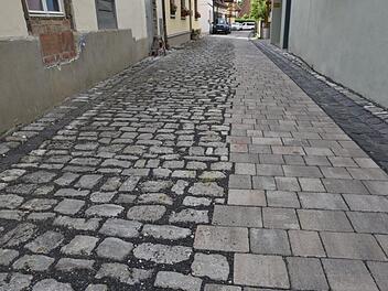 Gassen in der Königsberger Altstadt sind  vor allem für ältere Leute nur schwer begehbar. Eine Gehspur  würde Abhilfe schaffen.  Dass das geht, zeigt das Beispiel Tretgasse in Königsberg, wo durch einen Seitenstreifen das Kopfsteinpflaster "entstolpert" wurde.  Gerold Snater