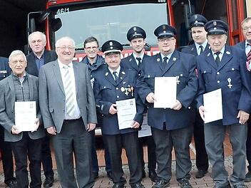 Ehrungen bei der Feuerwehr Burggrub: Mit im Bild sind Landratsstellvertreter Bernd Steger (Sechster von links) sowie (von links) Vorsitzender Dirk Kreul, Kommandant Dirk Raupach, KBI Harald Schnappauf (Vierter von links) und (von rechts) Bürgermeister Rainer Detsch, KBR Joachim Ranzenberger und Pfarrer Michael Foltin. Foto: Karl-Heinz Hofmann