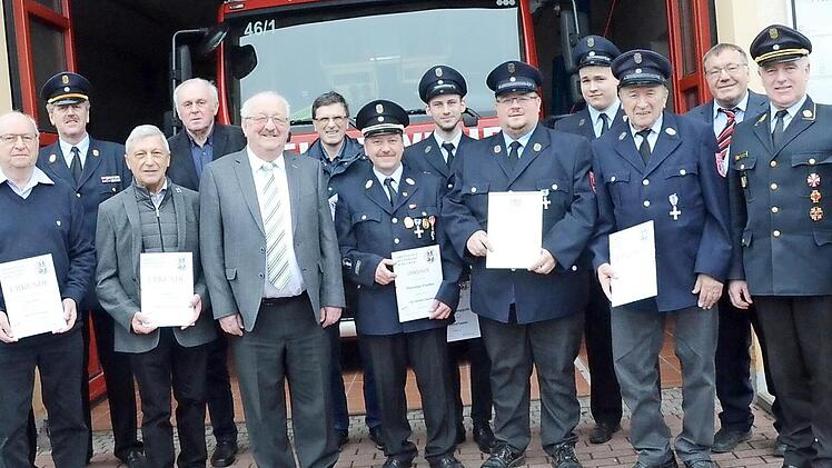 Ehrungen bei der Feuerwehr Burggrub: Mit im Bild sind Landratsstellvertreter Bernd Steger (Sechster von links) sowie (von links) Vorsitzender Dirk Kreul, Kommandant Dirk Raupach, KBI Harald Schnappauf (Vierter von links) und (von rechts) Bürgermeister Rainer Detsch, KBR Joachim Ranzenberger und Pfarrer Michael Foltin. Foto: Karl-Heinz Hofmann