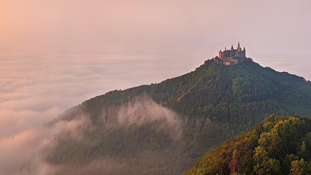 German Castle Burg Hohenzollern over the clouds at sunset landscape.Die deutsche Burg Hohenzollern über den Wolken bei Sonnenuntergang.