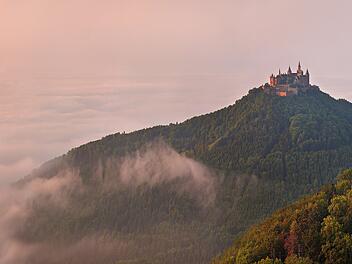 German Castle Burg Hohenzollern over the clouds at sunset landscape.Die deutsche Burg Hohenzollern über den Wolken bei Sonnenuntergang.