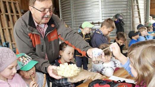 Lehrer Reinhold Mahr verteilt Käse an die Schüler.