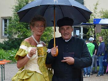 Gabriele Jopp verkörpert die Kaiserin Auguste Victoria, Alfred Dippacher neben ihr stellt den Pfarrer Johann Georg Schöppner dar. Die beiden hoffen, dass Bad Bocklet bald endlich mehr Glück mit dem Wetter hat. Foto: Björn Hein