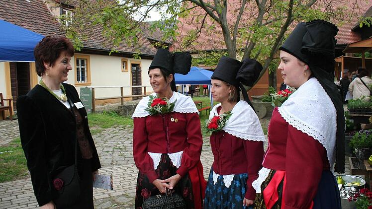 "Die Regnitztaler" aus Bamberg führen Museumsleiterin Birgit Jauernig (links) die Sonntagstracht der Bamberger Gärtner vor