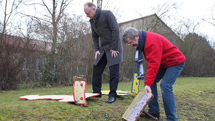 Bürgermeister Helmut Blank und Konrektor Michael Kübert (rechts) schauen sich die kaputten Holzskulpturen im Außenbereich der Freiherr-von-Lutz-Schule an. Es handelt sich um Schülerarbeiten aus dem Jahr 2007. Fotos : Heike Beudert