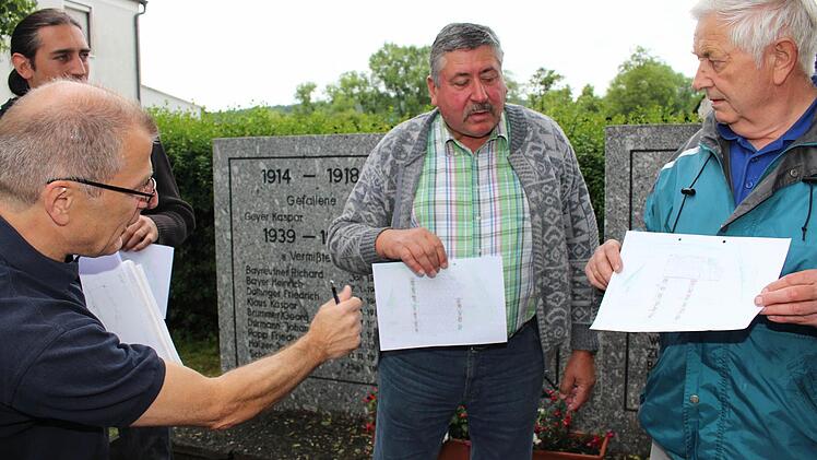 Willi Peters, Sprecher des Arbeitskreises Dorferneuerung (links) bei der Abwägung der Skizzen mit Ortsbewohnern  Foto: Evi Seeger