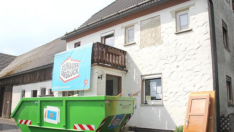 Der Schuttcontainer steht vor dem Haus und die blaue Sendungsflagge hängt über dem Eingang: "Zuhause im Glück" ist in Hesselbach. Foto: Andreas Schmitt