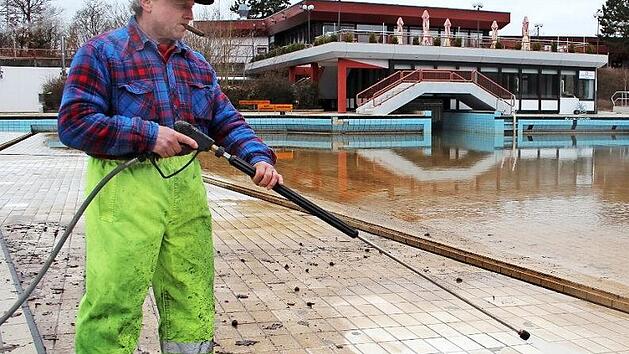 Thomas Malzer, Hausmeister des H&ouml;chstadter Freibads, reinigt die Fliesen eines Au&szlig;enbeckens mit einem Hochdruckreiniger. Foto: Franziska Rieger
