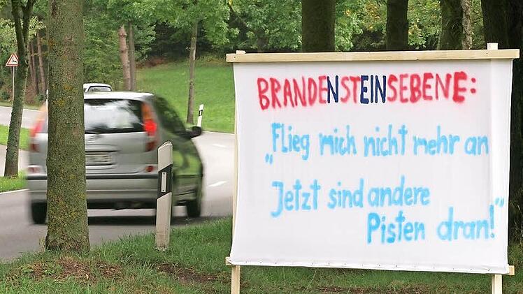 Seit einigen Tagen hängen in den Stadtteilen Rögen, Lützelbuch und Seidmannsdorf zahlreiche Protest-Plakate gegen einen Ausbau der Brandensteinsebene. Doch die Gegner eines Flugplatz-Neubaus wollen den jetzt auch nicht mehr. Foto: Christoph Winter