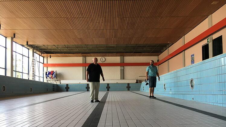 Das  Bischberger Hallenbad ist seit einem Jahr geschlossen, das Wasser abgelassen, so das Bürgermeister Johann Pfister (links) und Geschäftsleiter Michael Dütsch das Becken trockenen Fußes durchschreiten können. Foto: Anette Schreiber
