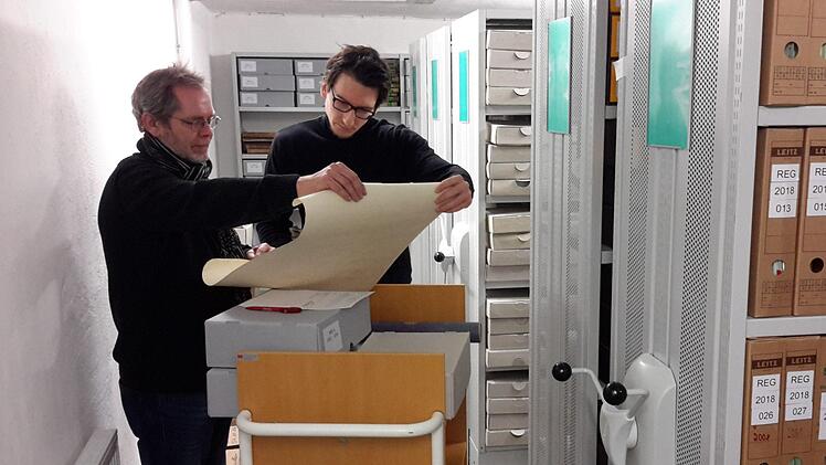 Ein funktionierendes Archiv braucht jede Stadt. In Bad Brückenau sind dafür Jan Marberg (rechts) und Roland Heinlein vom Kulturbüro zuständig. Regelmäßig sichten, pflegen und ordnen sie im Keller unter dem Rathaus am Marktplatz den Bestand an Urkunden, Akten und Plänen. Die Digitalisierung der Unterlagen geht voran.Foto: Rolf Pralle