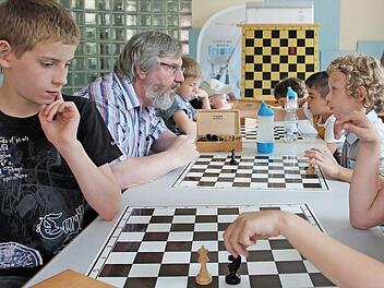 Dame schlägt Pferd. Wie viele Züge sind notwendig? Gabriel (links) und Max (rechts sind noch ins Spiel vertieft. Georg Klepp gibt Finn, dem Jüngsten, noch etwas Hilfestellung.