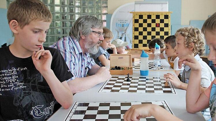 Dame schlägt Pferd. Wie viele Züge sind notwendig? Gabriel (links) und Max (rechts sind noch ins Spiel vertieft. Georg Klepp gibt Finn, dem Jüngsten, noch etwas Hilfestellung.