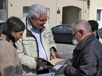 Peter Bernhardt (rechts)  und andere Besucher aus Potsdam zeigen Rolf Kießling (Mitte) den "Familienschatz", die Jugenderinnerungen von Kathie Zeiller. Foto: privat