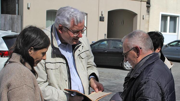 Peter Bernhardt (rechts)  und andere Besucher aus Potsdam zeigen Rolf Kießling (Mitte) den "Familienschatz", die Jugenderinnerungen von Kathie Zeiller. Foto: privat