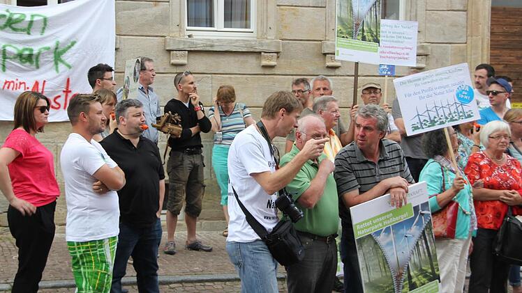 Ralph Bremicker (Mitte, weißes T-Shirt) spricht mit anderen Teilnehmern.