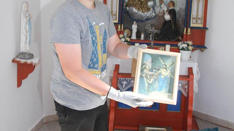 Max Tempel zeigt den Kreuzweg. Die Bilder wurden auf einem Dachboden gefunden und neu gerahmt.