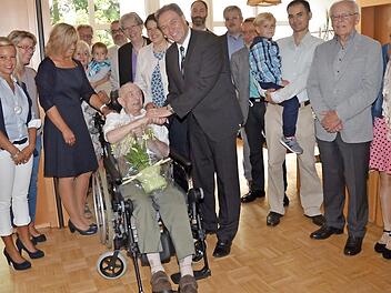 Rudolf Sünderhauf (sitzend) wurde 100. Zu den Gratulanten zählten der Familienkreis und Vertreter der GdP und der Leitung des Lucas-Cranach-Hauses sowie Landrat Klaus Löffler (vorne Mitte), 2. Bürgermeisterin Angela Hofmann (links neben Landrat) und Dekanin Dorothea Richter (links neben Angela Hofmann). Foto: K.- H. Hofmann