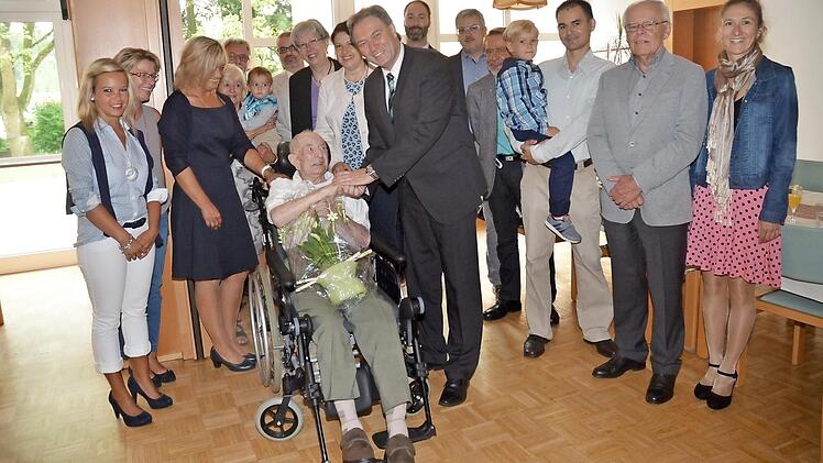 Rudolf Sünderhauf (sitzend) wurde 100. Zu den Gratulanten zählten der Familienkreis und Vertreter der GdP und der Leitung des Lucas-Cranach-Hauses sowie Landrat Klaus Löffler (vorne Mitte), 2. Bürgermeisterin Angela Hofmann (links neben Landrat) und Dekanin Dorothea Richter (links neben Angela Hofmann). Foto: K.- H. Hofmann