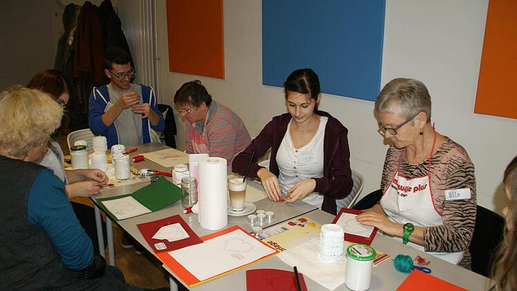 Ganz alte Schule: Gemeinsam gestalteten Seniorinnen und Berufsfachschülerinnen Karten mit Fadenornamenten und individuelle Teelicht-Gläser. Foto: Sabine Weinbeer